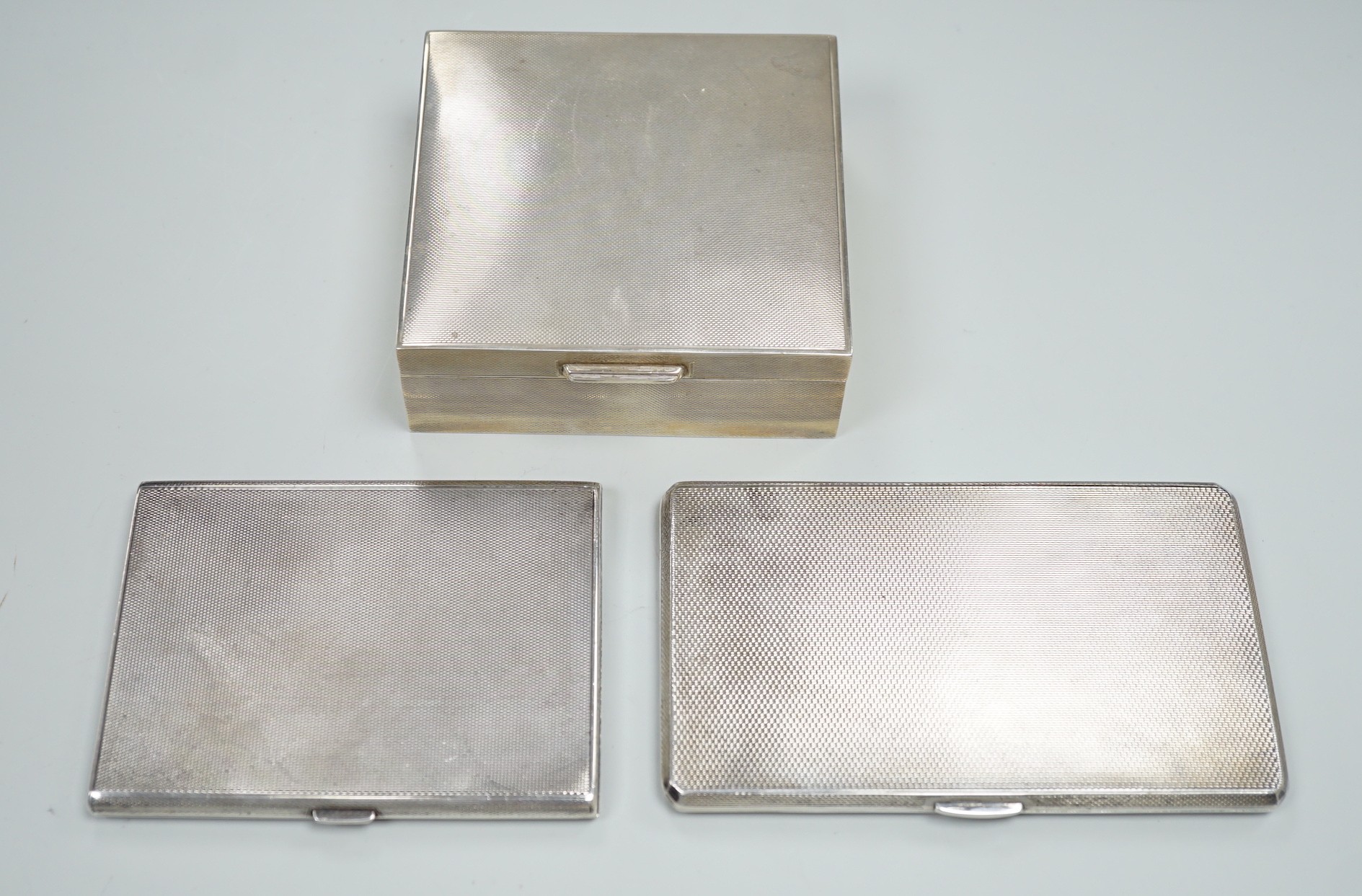 Two 1930's/1940's engine turned silver cigarette cases, largest 14cm and a later silver mounted cigarette box.